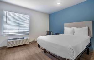 a bedroom with a large white bed and a window at Extended Stay America Select Suites - Beaumont in Beaumont