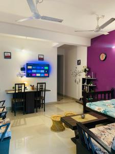 - un salon avec des murs violets, une table et des chaises dans l'établissement Raga Homestay 2BHK- A homely guesthouse experience, à Guwahati