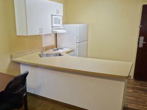 a kitchen with a sink and a white refrigerator at Extended Stay America Suites - Raleigh - Midtown in Raleigh