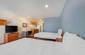 コロラドスプリングスにあるExtended Stay America Select Suites - Colorado Springs - Airportのベッド2台とテレビが備わるホテルルームです。