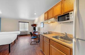a kitchen with a sink and a bed in a room at Extended Stay America Select Suites - Colorado Springs - Airport in Colorado Springs