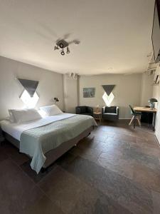 a bedroom with a large bed and two windows at Hotel de Watertoren in Dordrecht
