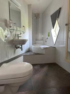 Baño blanco con lavabo y aseo en Hotel de Watertoren, en Dordrecht