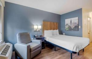 Habitación pequeña con cama y silla en Extended Stay America Select Suites - Charlotte - Airport, en Charlotte