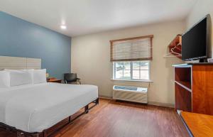 a bedroom with a bed and a television and a window at Extended Stay America Select Suites - Atlanta - Chamblee in Atlanta