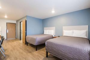 two beds in a room with blue walls at Extended Stay America Select Suites - Cleveland - Airport in Cleveland
