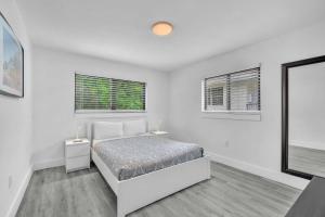 a white bedroom with a bed and two windows at West Brickell - #3 - Renovated 2 1 & Parking in Miami