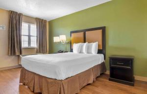 a large bed in a hotel room with green walls at Extended Stay America Select Suites - Columbia - Ft Jackson in Columbia