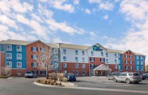 a hotel with cars parked in a parking lot at Extended Stay America Select Suites - Denver - Aurora in Aurora