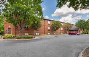 a parking lot in front of a brick building at Extended Stay America Select Suites - Charlotte - University Place - E McCullough Dr in Charlotte