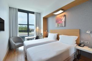 una camera d'albergo con due letti e una finestra di Hilton Garden Inn Milan North a Milano