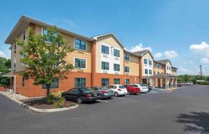 un estacionamiento con autos estacionados frente a un edificio en Extended Stay America Suites - Philadelphia - Cherry Hill, en Maple Shade