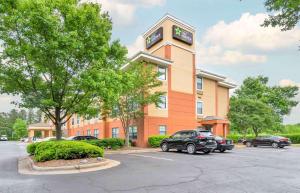 ein Gebäude mit einem Uhrturm auf einem Parkplatz in der Unterkunft Extended Stay America Suites - Charlotte - Tyvola Rd in Charlotte