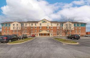 a large brick building with cars parked in a parking lot at Extended Stay America Select Suites - Cincinnati - Florence - Airport in Florence