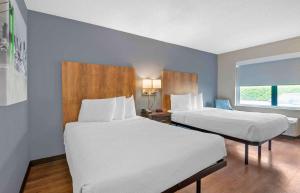 シャーロットにあるExtended Stay America Suites - Charlotte - Tyvola Rdのベッド2台と窓が備わるホテルルームです。