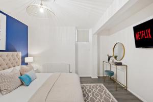 een slaapkamer met een bed, een spiegel en een tv bij Bright 1 Bed with free NETFLIX in Chatham