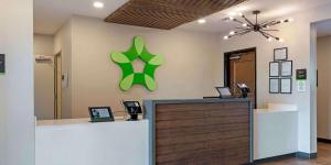 a reception desk with a green sign on a wall at Extended Stay America Premier Suites - Savannah - Pooler in Savannah