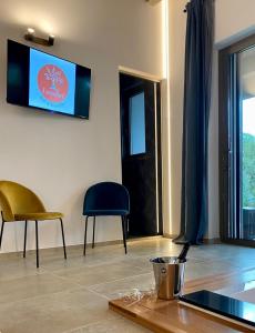 sala de estar con TV, mesa y sillas en I SECOLARI en Sannicandro di Bari