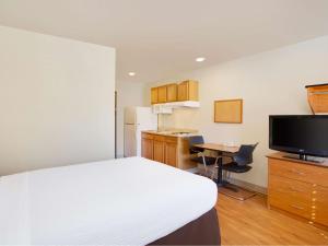 Habitación con cama, escritorio y TV. en Extended Stay America Select Suites - Birmingham - Pelham, en Pelham