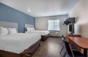 a hotel room with two beds and a desk at Extended Stay America Select Suites - Gainesville in Gainesville