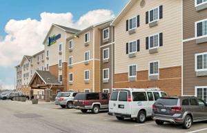 grupa samochodów zaparkowanych na parkingu przed budynkiem w obiekcie Extended Stay America Select Suites - Grand Rapids - Wyoming w mieście Wyoming