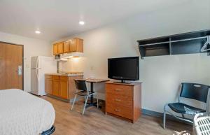 a room with a bed and a tv and a kitchen at Extended Stay America Select Suites - Indianapolis - Lawrence in Fishers