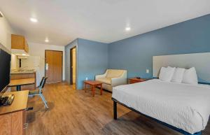 a hotel room with a bed and a kitchen at Extended Stay America Select Suites - Indianapolis - Lawrence in Fishers