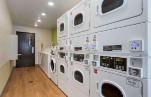 a laundry room with white washers and dryers at Extended Stay America Select Suites - Gulfport in Gulfport