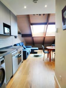 a kitchen and living room with a table and chairs at el Atico de la Camara, centro Aviles, nuevo a estrenar in Avilés