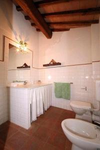 a white bathroom with two toilets and a sink at Agriturismo San Silvestro in San Donato in Poggio