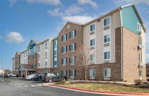 a large brick building with cars parked in a parking lot at Extended Stay America Select Suites - Indianapolis - West in Avon