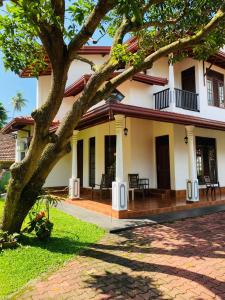 a house with a tree in front of it at White Villa in Weligama