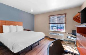 a bedroom with a bed and a desk and a window at Extended Stay America Select Suites - Jacksonville - North in Jacksonville