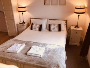 una camera da letto con un letto e due asciugamani di The Angerstein Hotel a Londra