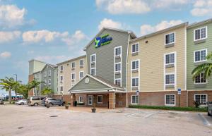 un hotel con coches estacionados en un estacionamiento en Extended Stay America Select Suites - Lake Worth en Lake Worth