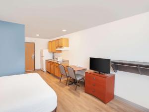 a hotel room with a bed and a desk with a television at Extended Stay America Select Suites - Austin - Round Rock in Round Rock