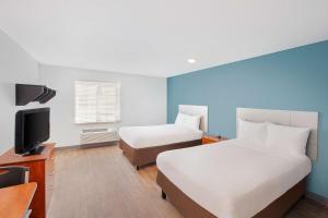 a hotel room with two beds and a television at Extended Stay America Select Suites - Austin - Round Rock in Round Rock