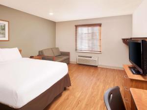 朗德羅克的住宿－Extended Stay America Select Suites - Austin - Round Rock，一间卧室配有一张床和一张书桌及电视
