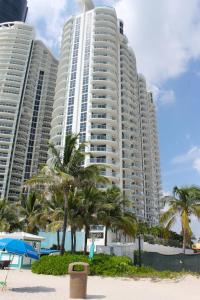 two tall buildings on the beach with palm trees at Marenas Beach Resort in Sunny Isles Beach