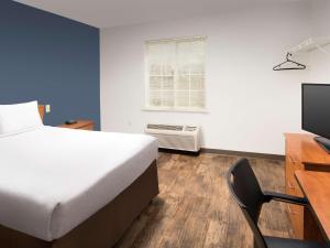 um quarto com uma cama, uma secretária e uma televisão em Extended Stay America Select Suites - Las Cruces em Las Cruces
