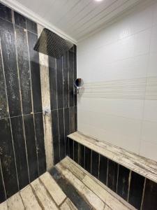 ducha con paredes de azulejos blancos y negros en Berg guest farm, en Winterton