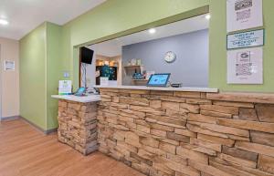 a lobby with a stone counter with two laptops on it at Extended Stay America Select Suites - Louisville - Airport in Louisville