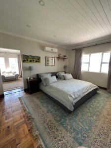 een slaapkamer met een groot bed en een tapijt bij Berg guest farm in Winterton