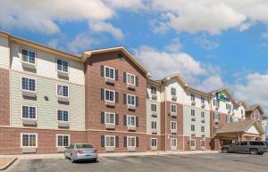 un gran edificio con coches estacionados en un estacionamiento en Extended Stay America Select Suites - Loveland, en Loveland