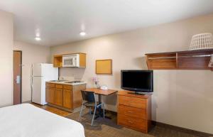 Habitación con cama y escritorio con TV. en Extended Stay America Select Suites - Loveland en Loveland