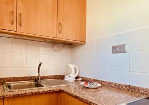 a kitchen with a sink and a counter top with a sink at Sunny apartment near the beach in Playa del Ingles