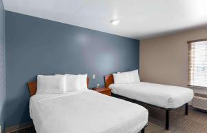 Duas camas num quarto com paredes azuis em Extended Stay America Select Suites - Loveland em Loveland