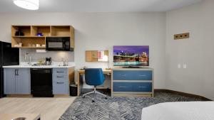 a kitchen with a desk and a blue chair in a room at Candlewood Suites San Antonio Downtown, an IHG Hotel in San Antonio