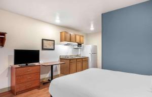 a bedroom with a bed and a desk with a television at Extended Stay America Select Suites - Louisville - South 