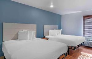 two beds in a room with blue walls at Extended Stay America Select Suites - Louisville - South 